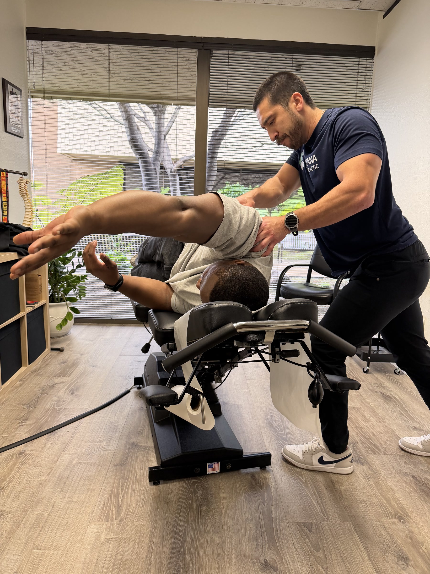 Dr. Mike performing soft-tissue work on a seated patient